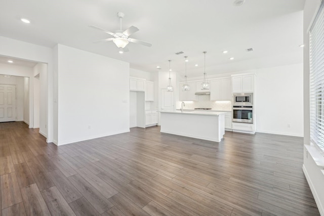 unfurnished living room featuring ceiling fan, dark hardwood / wood-style flooring, and sink