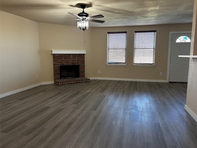 unfurnished living room featuring ceiling fan, a fireplace, and dark hardwood / wood-style floors