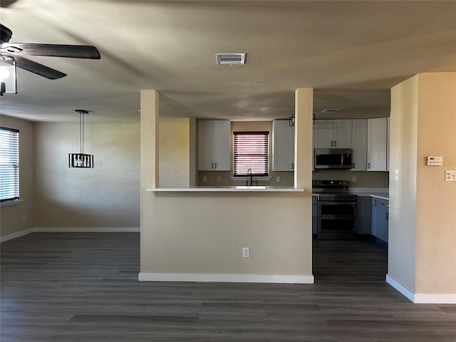 kitchen with double oven range, hanging light fixtures, white cabinets, and dark hardwood / wood-style flooring