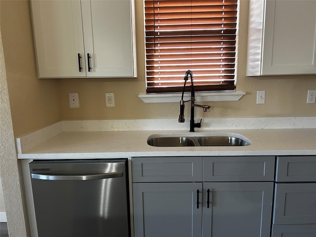 kitchen with light stone counters, sink, dishwasher, and gray cabinets