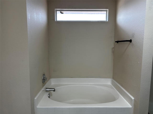 bathroom featuring tiled tub and plenty of natural light