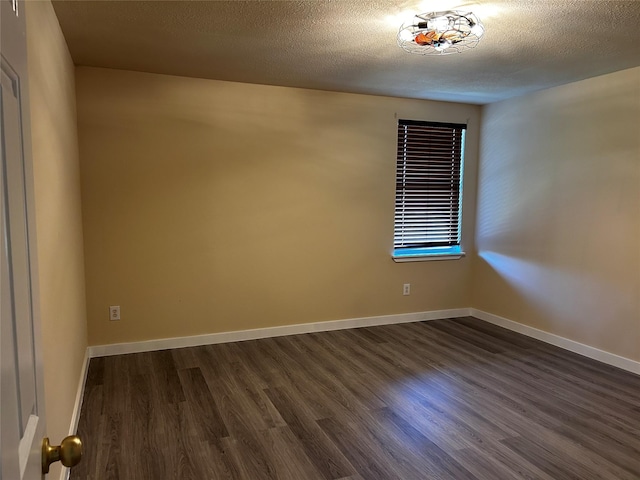 empty room featuring dark hardwood / wood-style floors and a textured ceiling