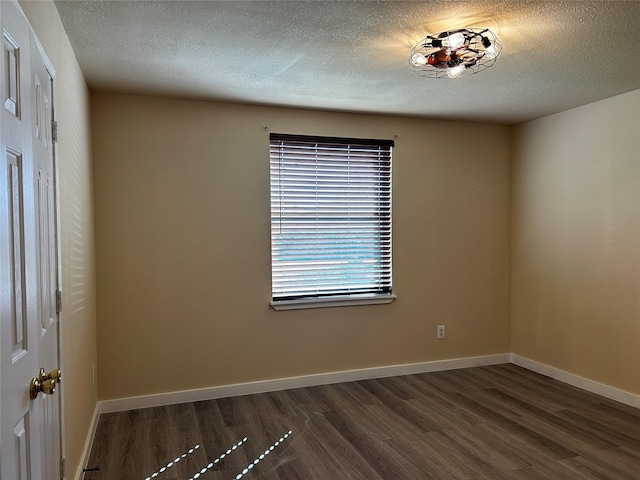 unfurnished room with a textured ceiling and dark hardwood / wood-style floors