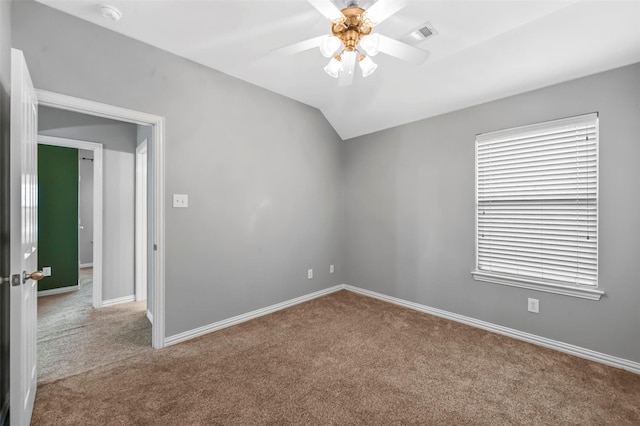 spare room with vaulted ceiling, ceiling fan, and light colored carpet