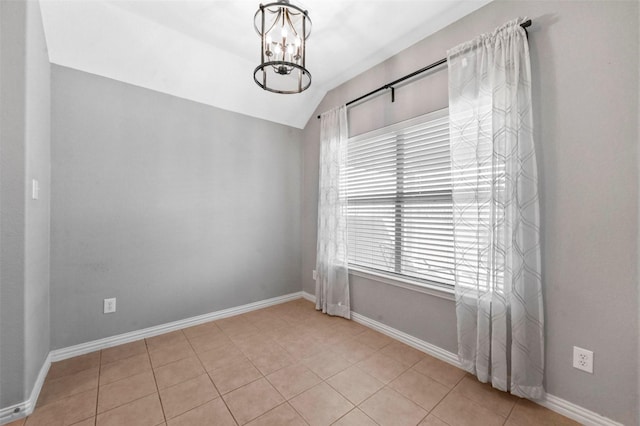 spare room with light tile patterned flooring, a chandelier, and vaulted ceiling