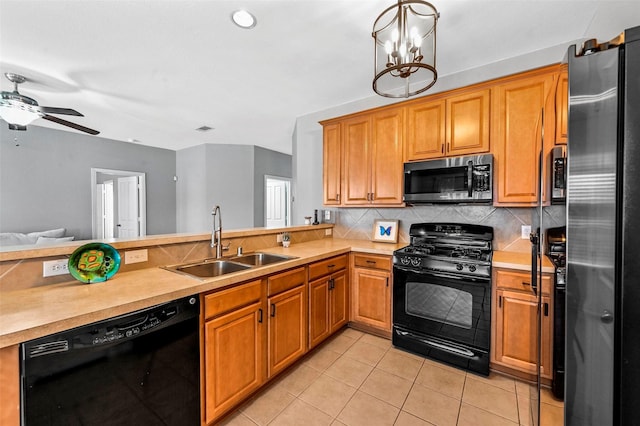 kitchen with decorative backsplash, light tile patterned flooring, black appliances, ceiling fan with notable chandelier, and sink