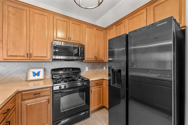 kitchen featuring light tile patterned floors, backsplash, refrigerator with ice dispenser, and black range with gas cooktop