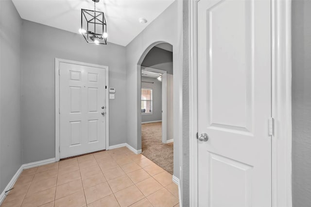 tiled entrance foyer with a notable chandelier