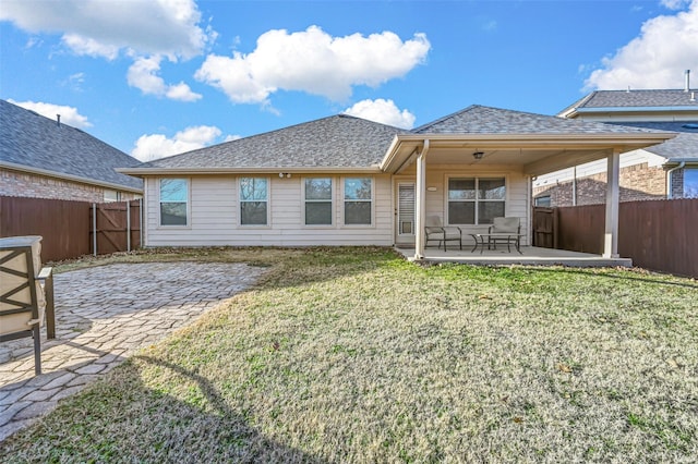 rear view of property featuring a lawn and a patio