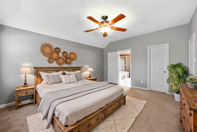 bedroom featuring ceiling fan, light colored carpet, ensuite bathroom, and lofted ceiling