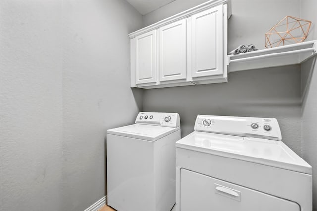 laundry room featuring cabinets and separate washer and dryer