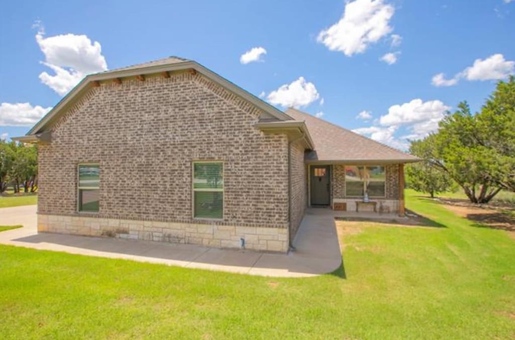 back of property featuring a patio area and a yard