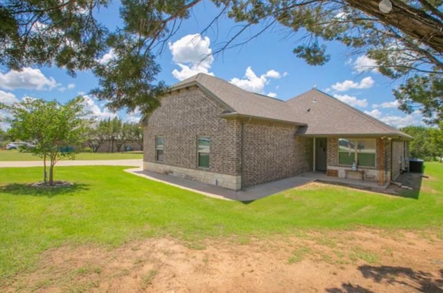 rear view of house with a lawn and central AC