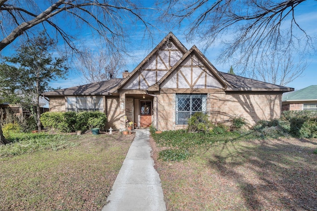 tudor-style house featuring a front yard