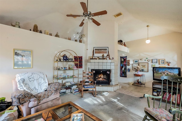 tiled living room featuring ceiling fan, high vaulted ceiling, and a tiled fireplace