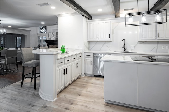 kitchen featuring dishwasher, sink, white cabinets, hanging light fixtures, and kitchen peninsula