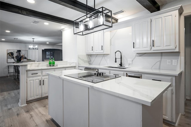 kitchen featuring a center island, kitchen peninsula, sink, and white cabinets