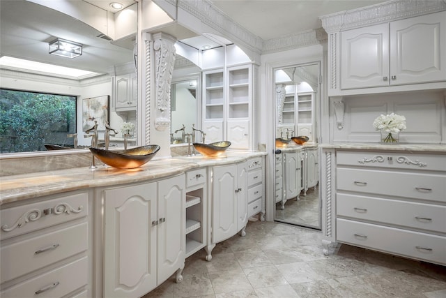 interior space with sink, crown molding, and white cabinets