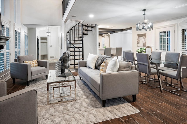 living room with dark hardwood / wood-style flooring, a healthy amount of sunlight, and a chandelier