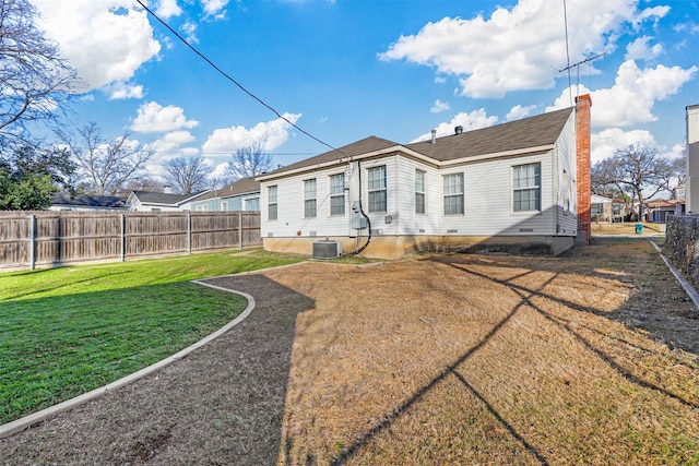 back of property with central air condition unit and a yard