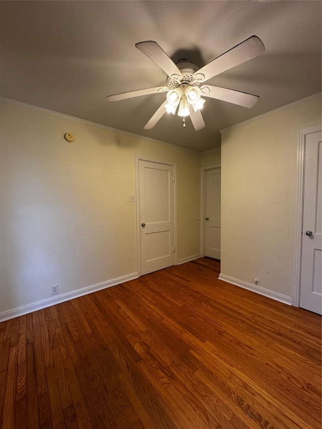 empty room featuring hardwood / wood-style flooring, ornamental molding, and ceiling fan