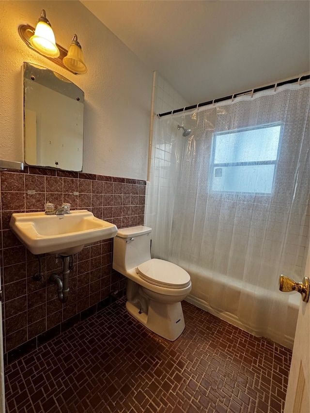 full bathroom with toilet, tile walls, sink, and shower / bathtub combination with curtain