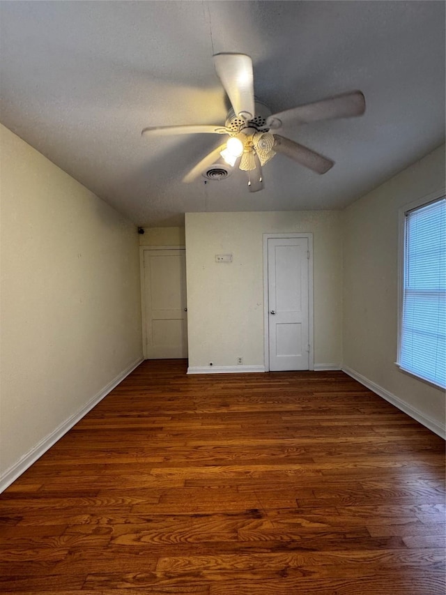 unfurnished room with ceiling fan, dark hardwood / wood-style floors, and a textured ceiling