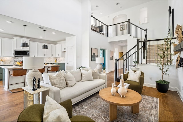 living room with hardwood / wood-style flooring and a towering ceiling