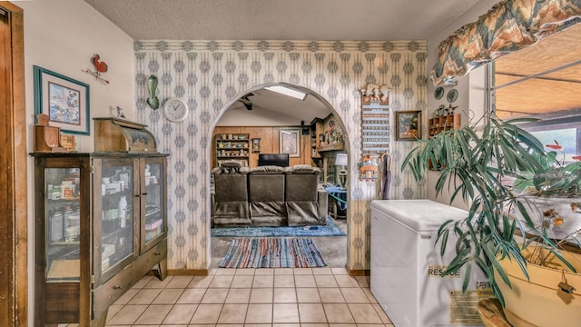 interior space with a textured ceiling and light tile patterned floors