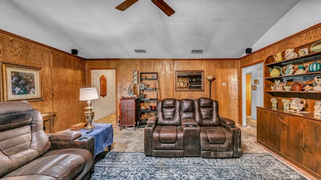 home theater featuring a textured ceiling, ceiling fan, lofted ceiling, and wood walls