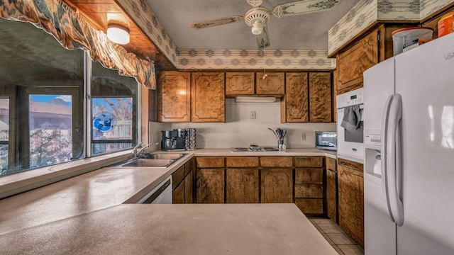 kitchen featuring ceiling fan, sink, white appliances, a textured ceiling, and light tile patterned floors