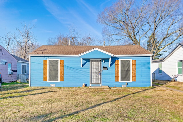 bungalow-style home with a front yard and cooling unit