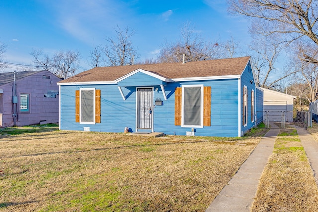 bungalow featuring a front yard, a garage, and an outdoor structure