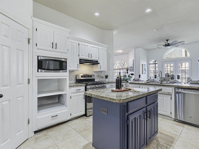 kitchen featuring french doors, appliances with stainless steel finishes, white cabinetry, and a center island