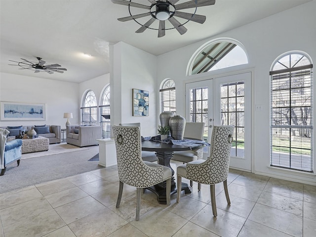 dining area with light tile patterned floors, ceiling fan, french doors, and light carpet