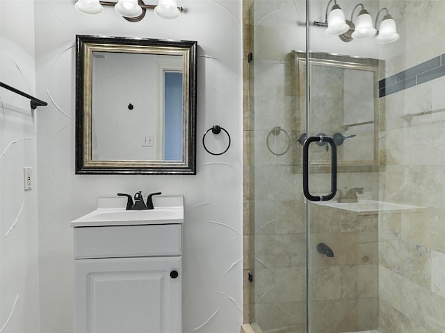 bathroom with a shower with shower door and vanity