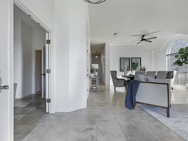 interior space with lofted ceiling, visible vents, ceiling fan, and baseboards