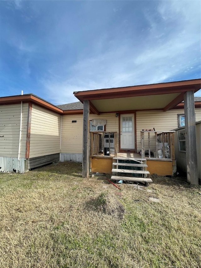 rear view of property featuring a lawn