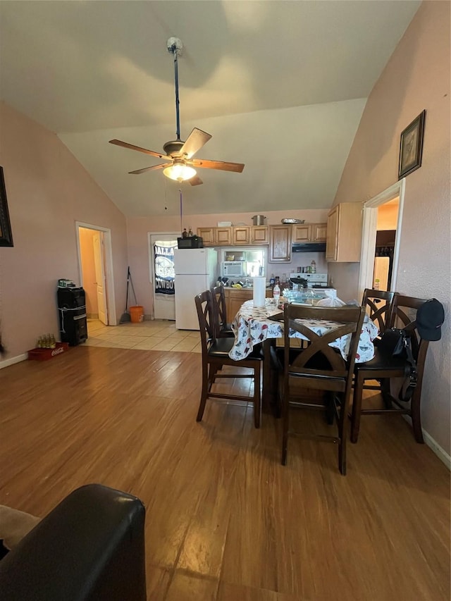 dining area with ceiling fan, light hardwood / wood-style flooring, and vaulted ceiling