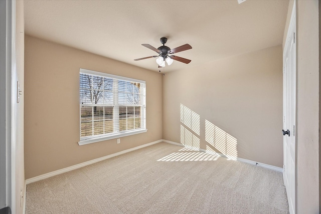 carpeted spare room with ceiling fan