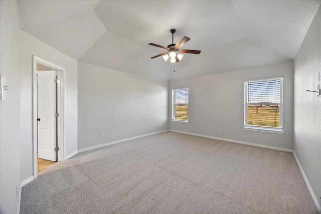 spare room with ceiling fan, a wealth of natural light, light carpet, and vaulted ceiling