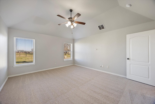 empty room featuring vaulted ceiling, ceiling fan, and light colored carpet