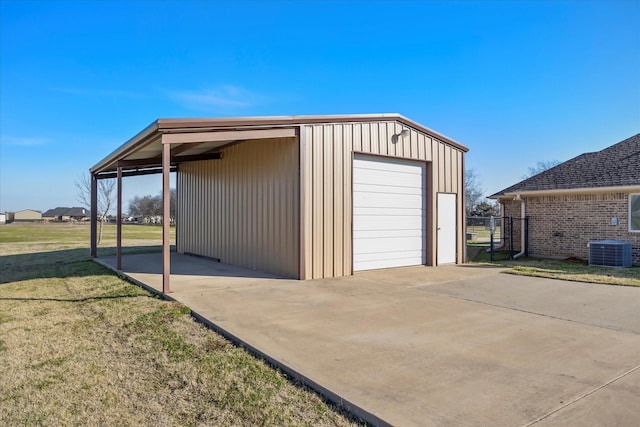 garage with central air condition unit and a lawn