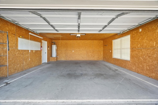 garage featuring electric water heater and wood walls