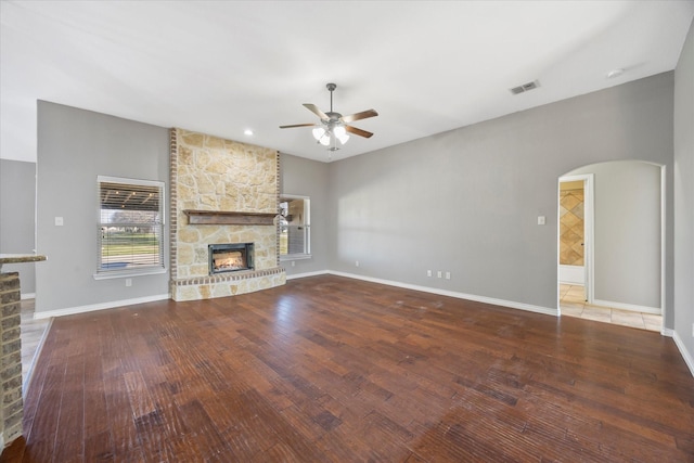 unfurnished living room featuring ceiling fan, wood-type flooring, and a fireplace