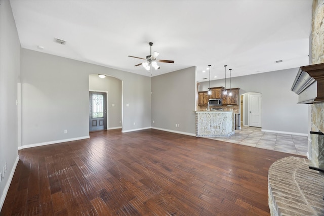 unfurnished living room with ceiling fan and light wood-type flooring