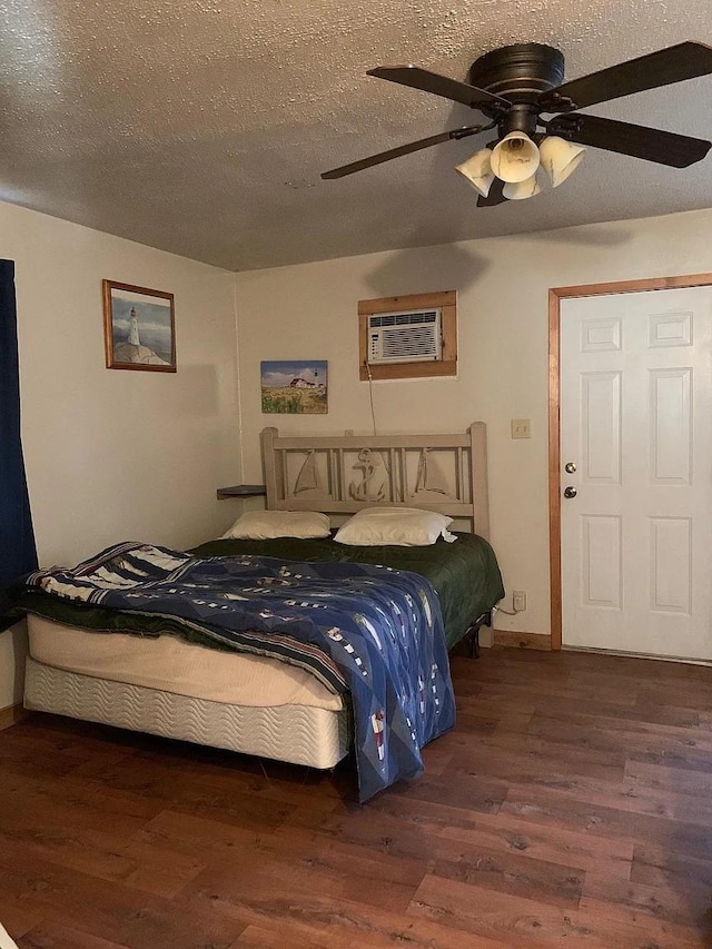 bedroom featuring ceiling fan, dark hardwood / wood-style flooring, a textured ceiling, and a wall unit AC