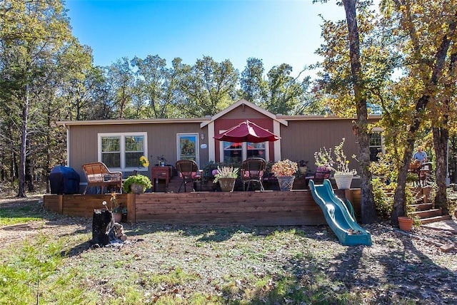 rear view of house featuring a playground