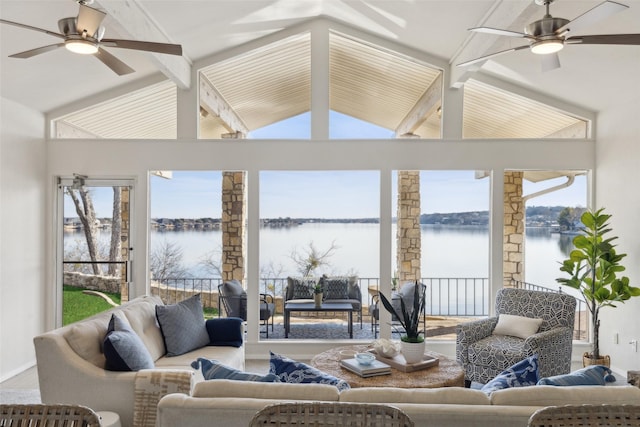 sunroom with ceiling fan, a water view, and vaulted ceiling