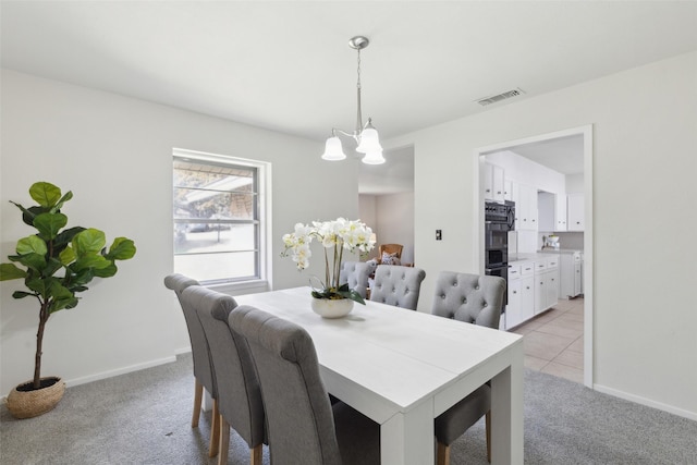 dining area featuring light carpet and a notable chandelier